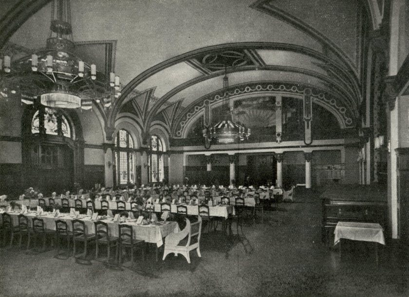 Historische Fotografie des großen Festsaals mit gewölbter Decke, Kronleuchtern und festlich gedeckten Tafeln